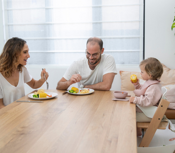 Family enjoying mess-free meal with food-catching mat, protecting floors and simplifying cleanup