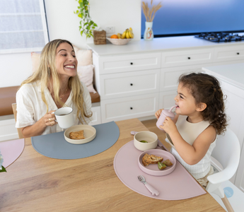 Mom and toddler eating at table with mess-free silicone placemats, easy clean food catcher for meals