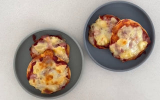 Two gray plates with mini cheesy pizzas on a clean countertop, perfect for mess-free meals.