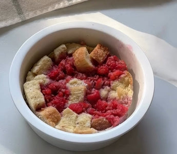 Raspberry bread pudding in white ramekin, fresh baked dessert with juicy berries and golden cubes