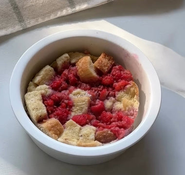 Raspberry bread pudding in white ramekin, fresh baked dessert with juicy berries and golden cubes