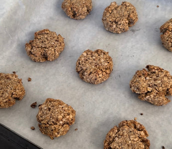 Freshly baked oatmeal cookies on parchment paper, perfect for mess-free snacking with CATCHY.