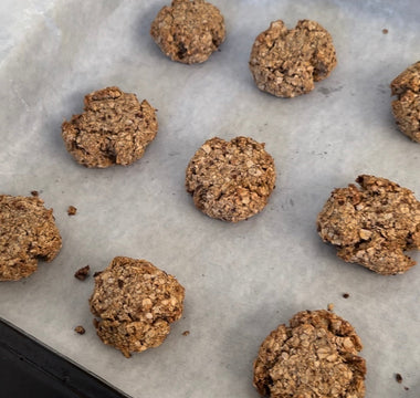 Freshly baked oatmeal cookies on parchment paper, perfect for mess-free snacking with CATCHY.